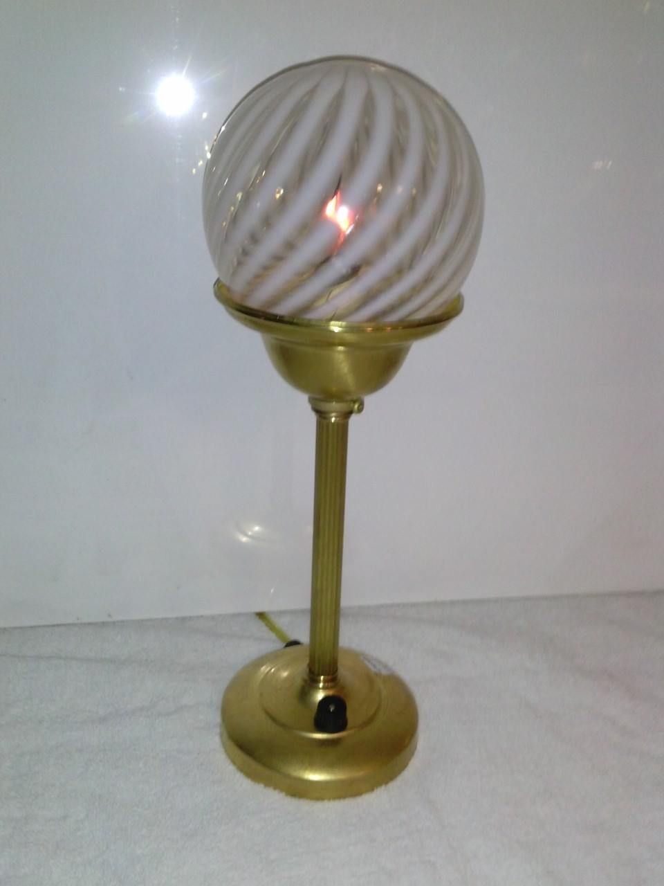 Brass desk lamp with white and gold swirl glass globe shade.