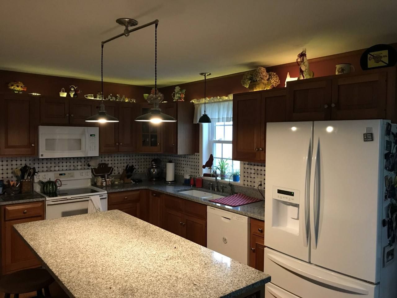 Kitchen with wooden cabinets, granite countertops, and white appliances.