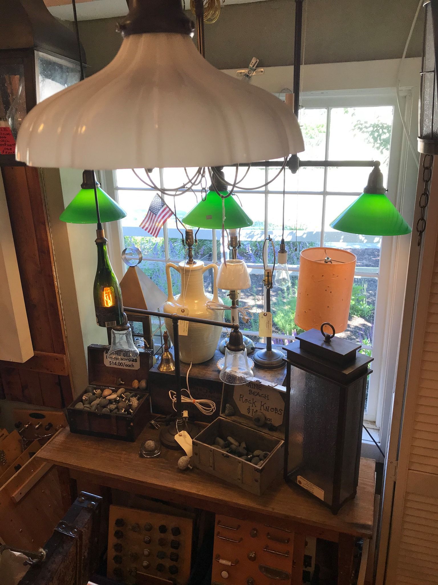 Antique store display with lamps and various items in front of a window.