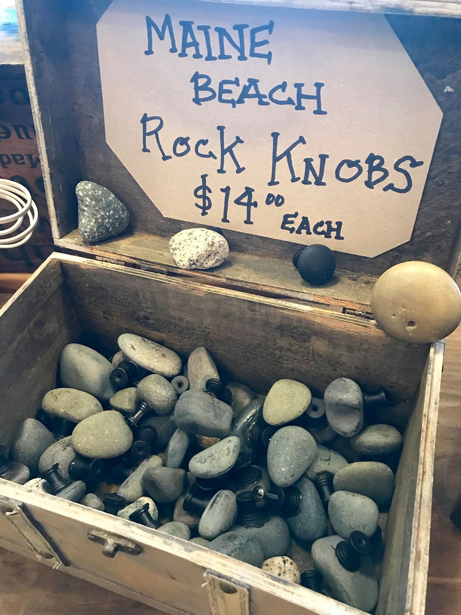 Wooden box filled with Maine beach rock knobs. Sign: 