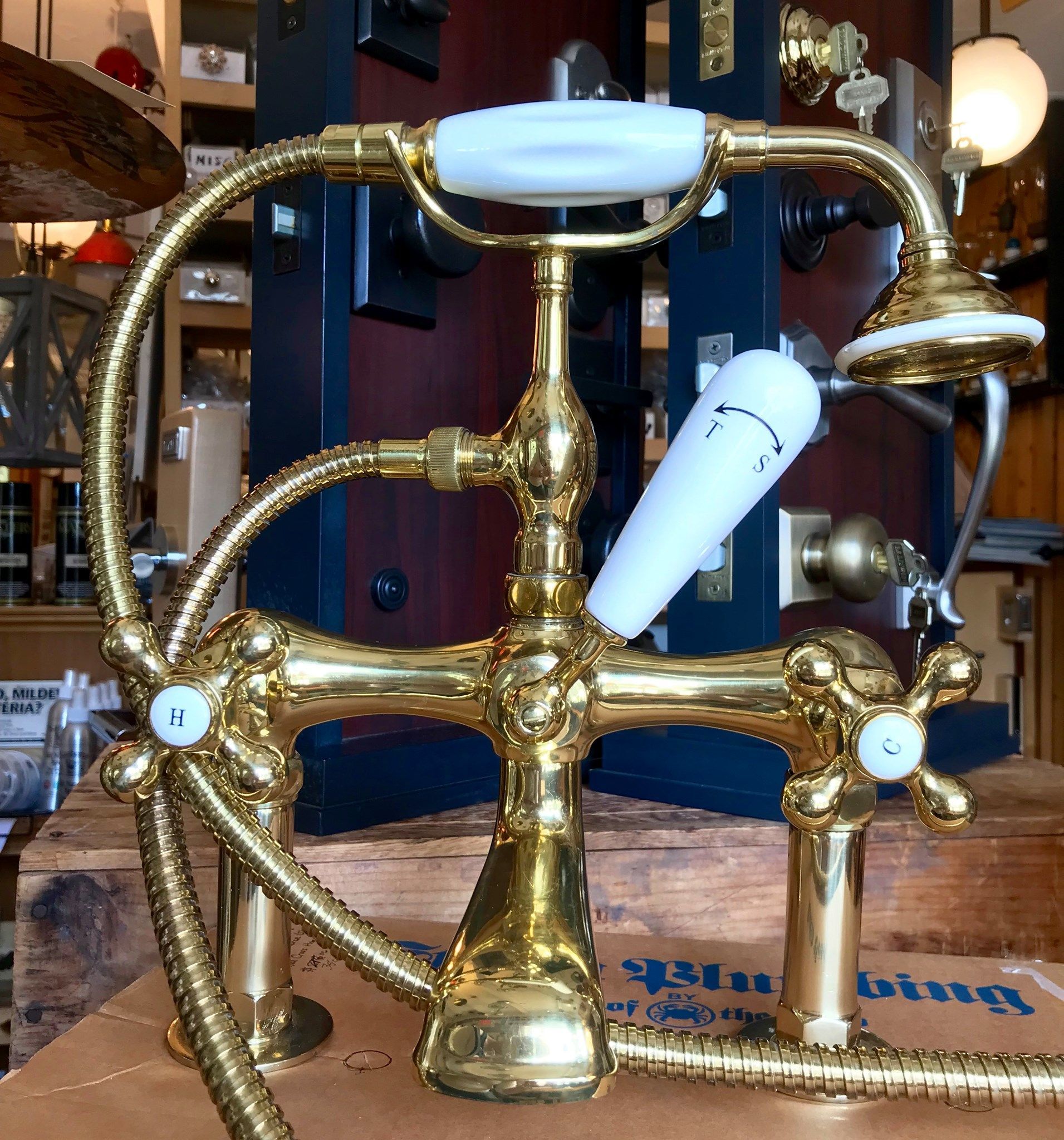 Gold-colored, vintage-style bathtub faucet with white handles.