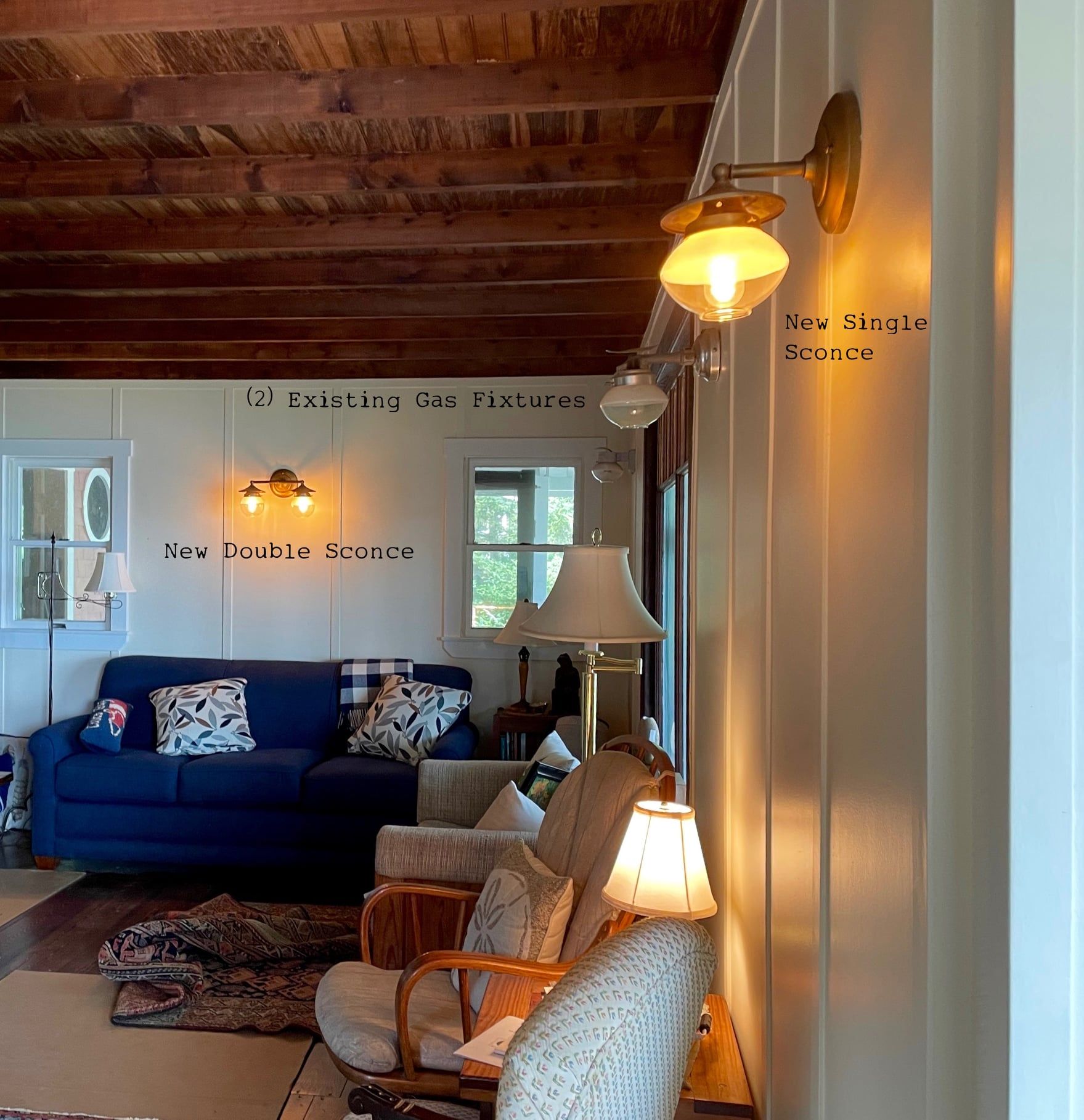 Cozy living room with a blue couch, chairs, and several sconces and lamps.