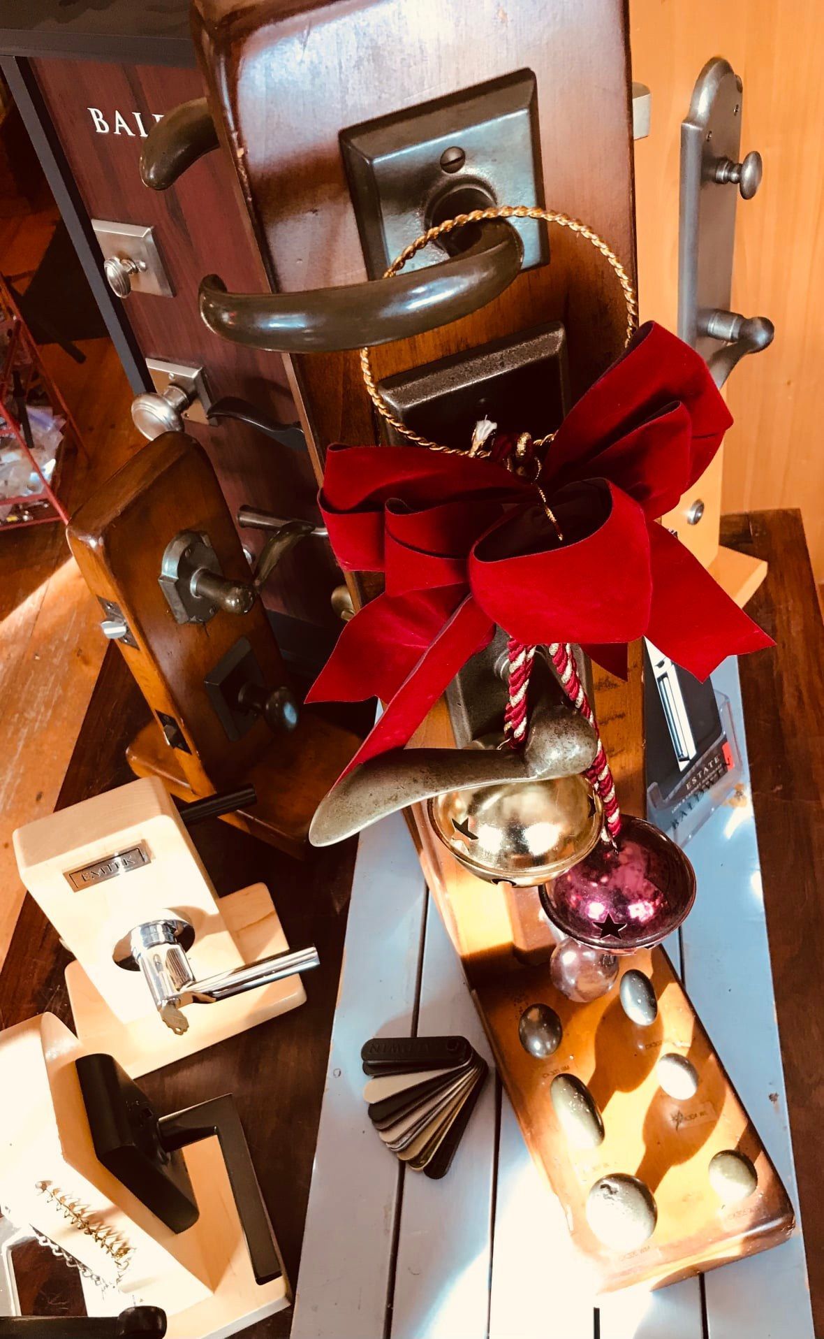Assortment of antique door handles, decorated with a red bow and ornaments.