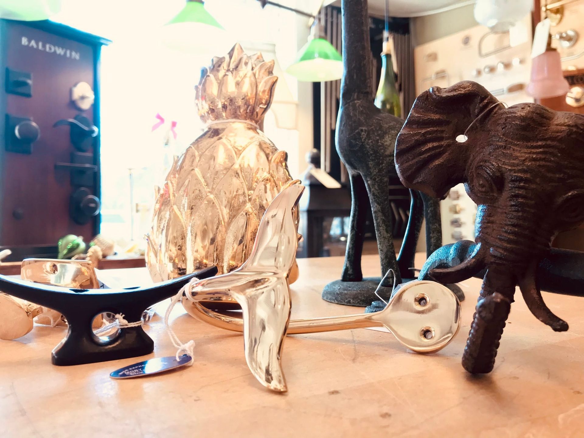 Tabletop display of decorative items, including a golden pineapple, an elephant, and a giraffe statue.