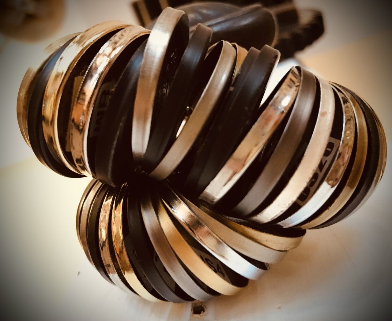 Stacked bracelets, silver and black, clustered together.