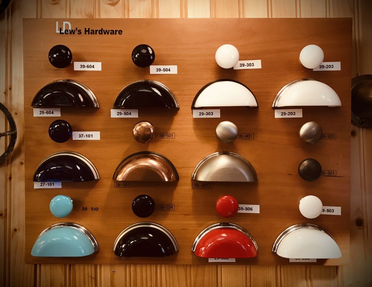 Display board of cabinet hardware samples in various colors and styles.