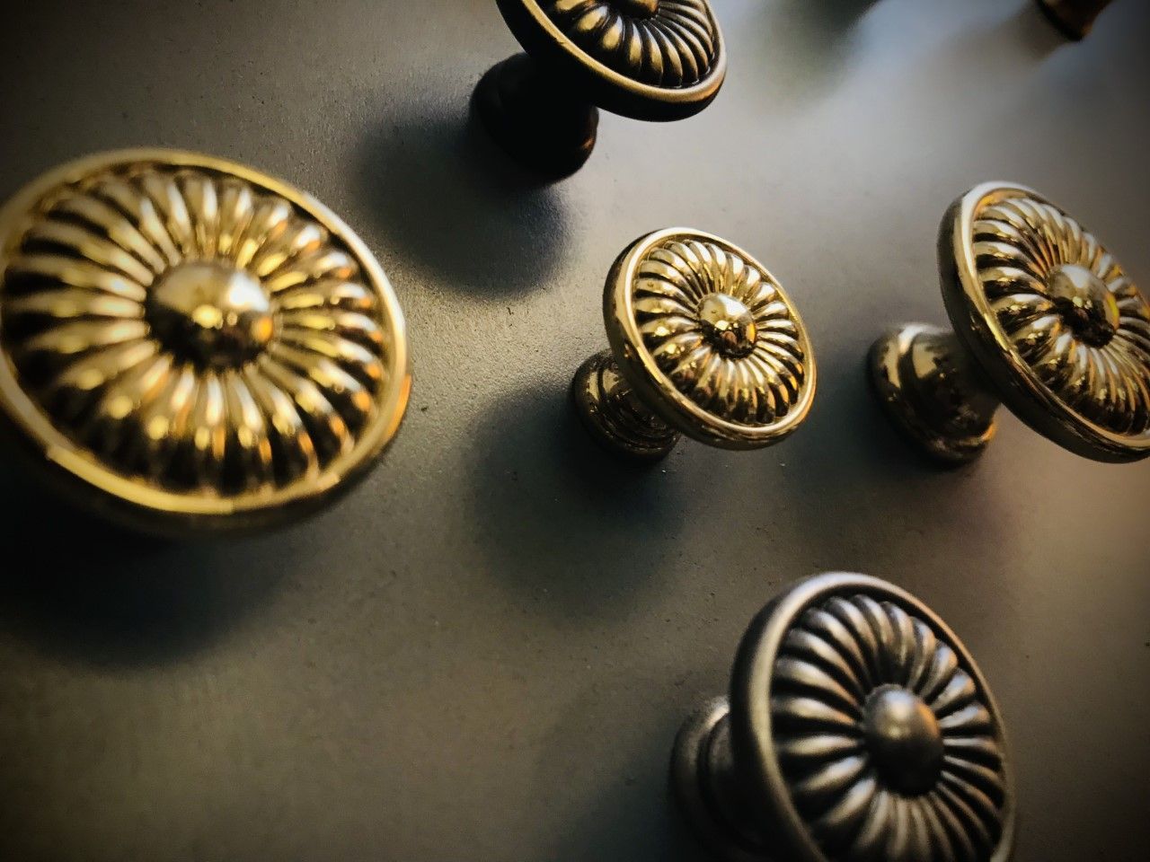 Gold decorative knobs arranged on a gray surface.