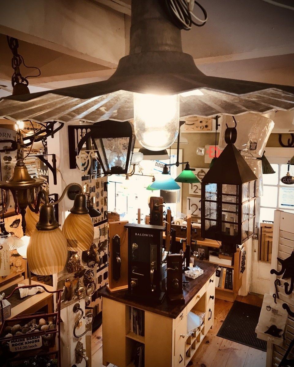 Interior shop display, vintage lighting fixtures, lamps, and hardware. Wooden display, various shapes, and glass.