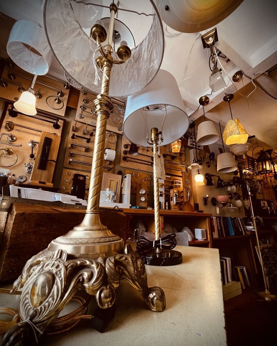 Antique lamps on display in a shop, with ornate bases and various light fixtures.