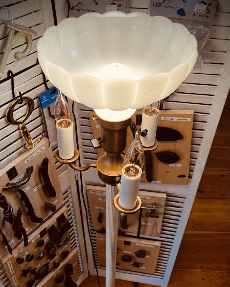 White vintage floor lamp with three candelabra bulbs and a scalloped glass shade.