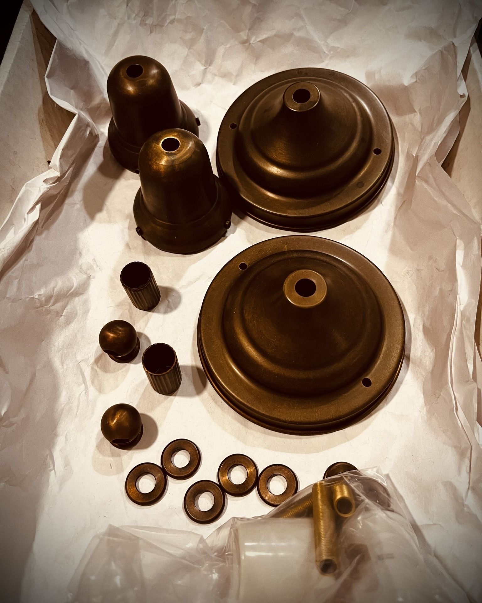 Brass light fixture components in a box.