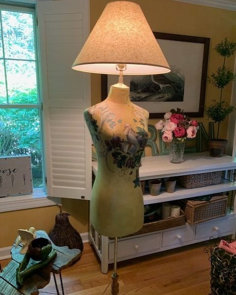 A unique lamp crafted from a dressmaker's form, featuring a lampshade atop.