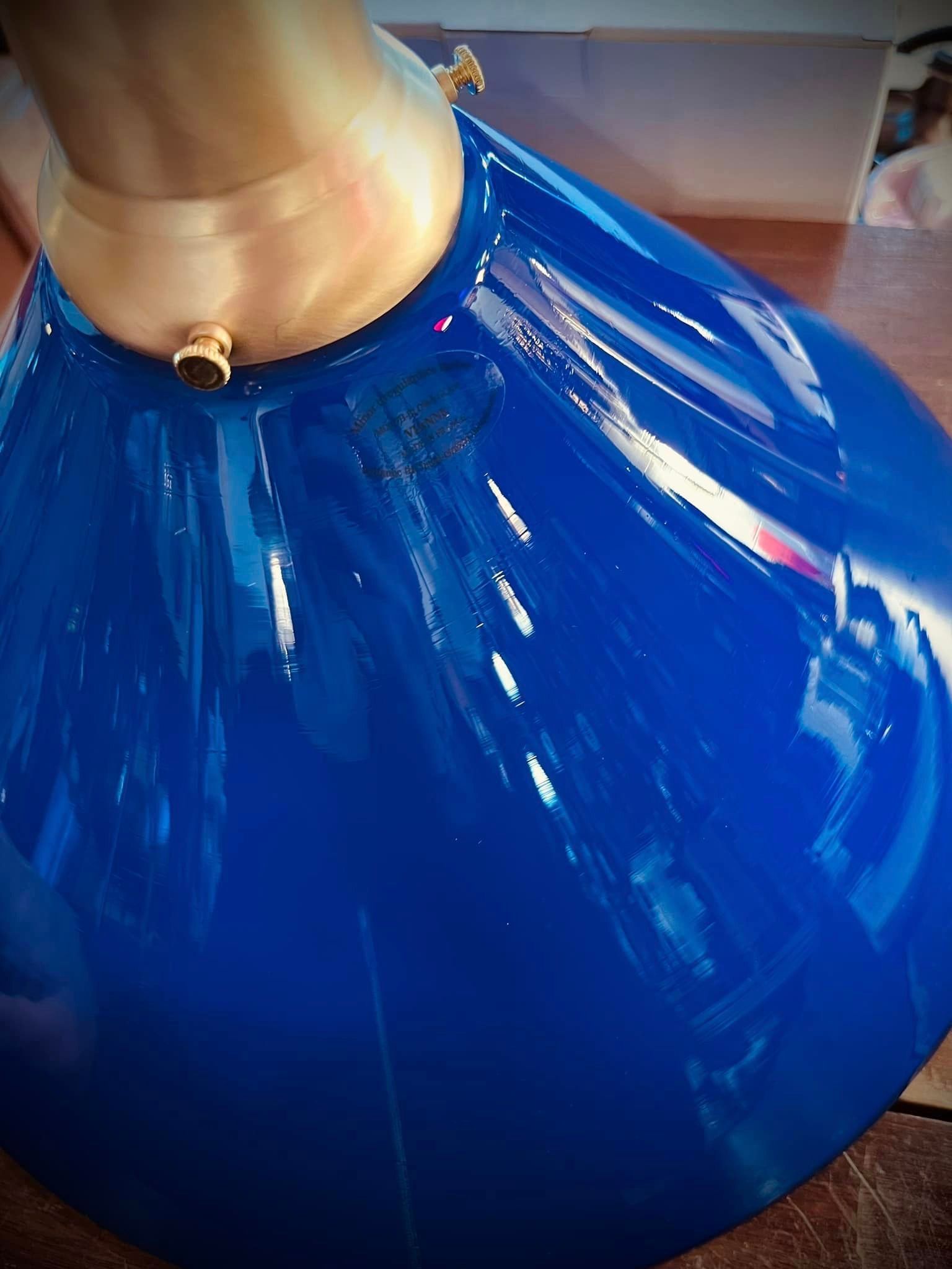 Blue shiny object with a golden neck, possibly a lamp.