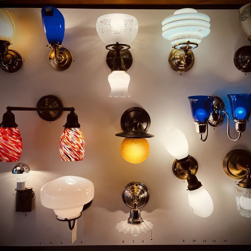 Wall-mounted vintage light fixtures in various shapes, colors, and styles against a neutral background.