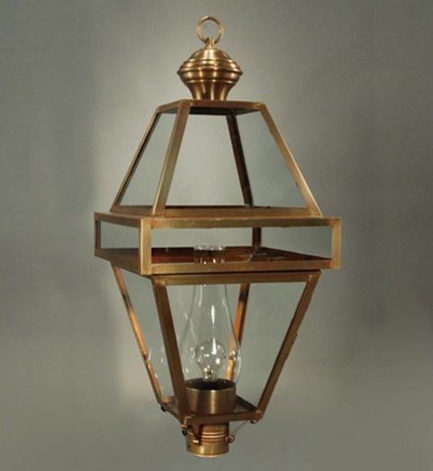 Brass geometric hanging lantern with glass panels and a lightbulb.