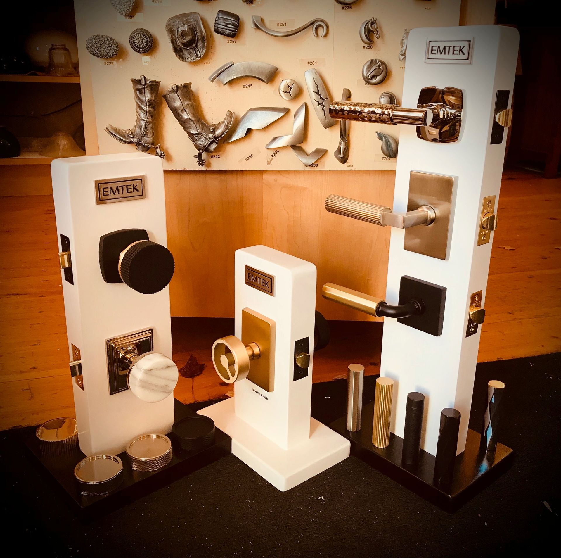 Displays of door hardware, including knobs, levers, and handles, on white stands in a store.