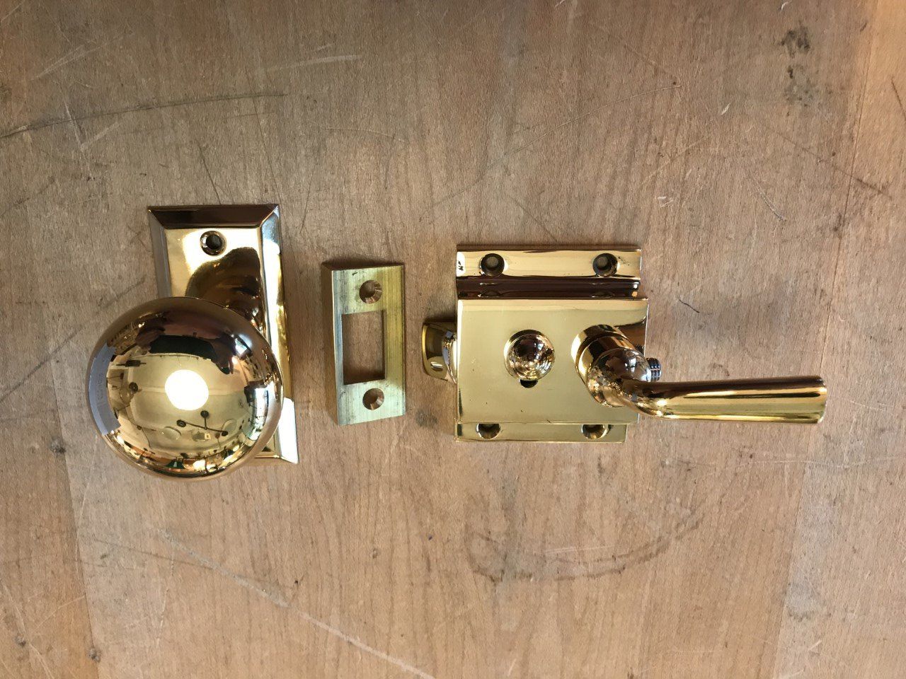 Brass door latch set on a wooden surface.