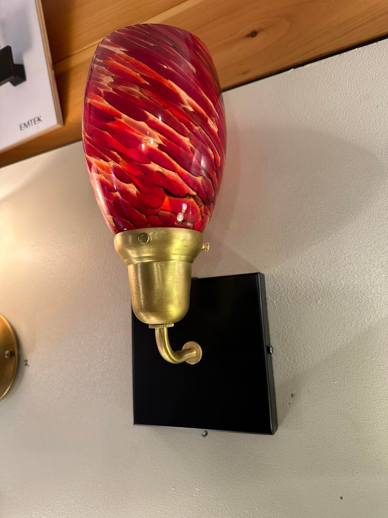 Red and gold glass wall sconce with a black square mount.