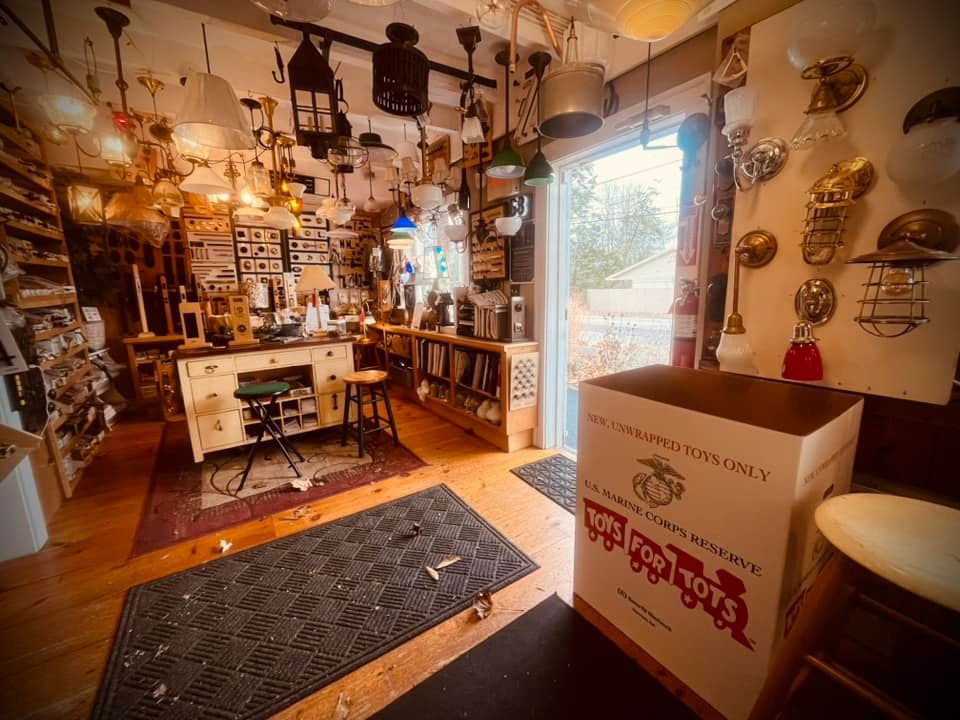 Workshop interior with various light fixtures. Work table, open door, and cardboard box.