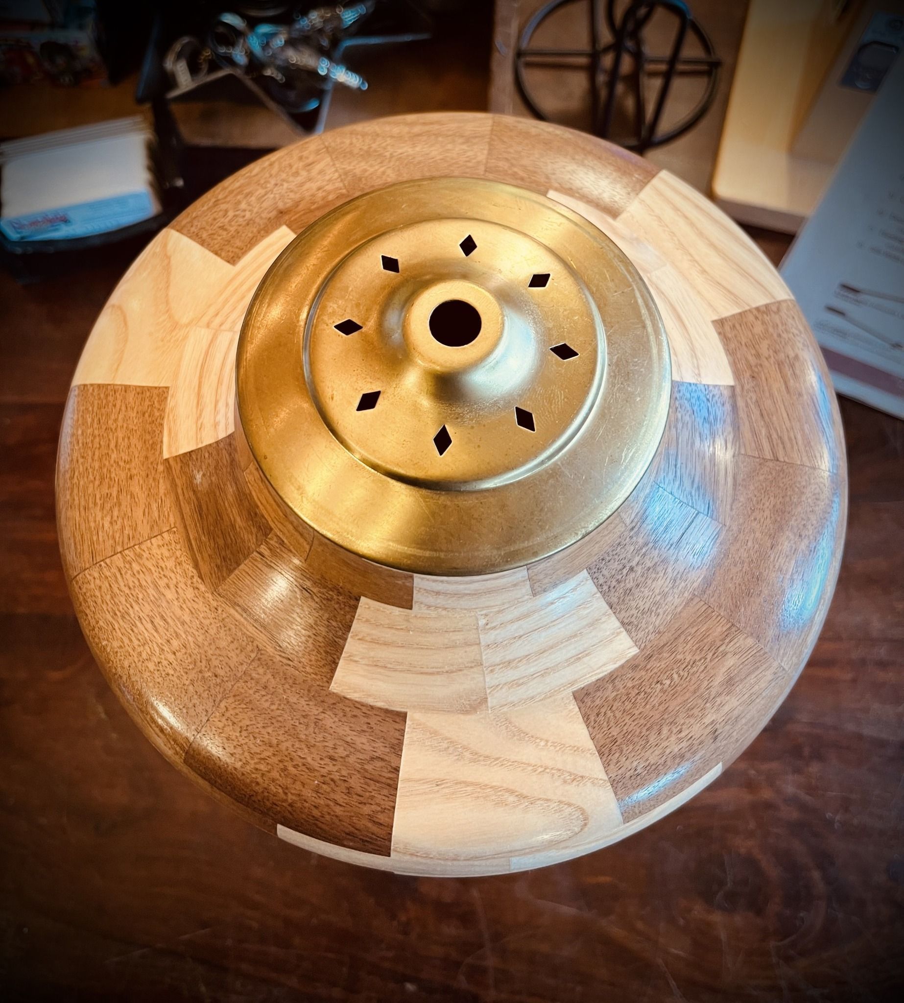 Wooden bowl with brass top; alternating light and dark wood segments.