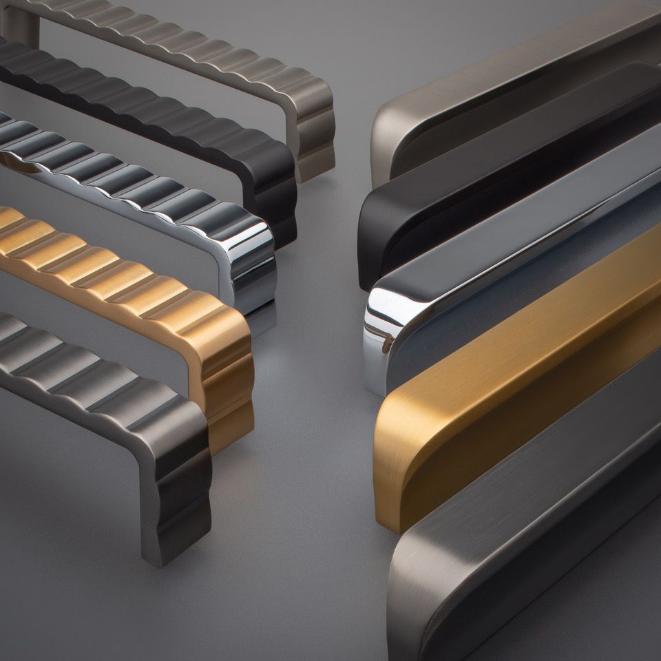 Cabinet handles in various metallic finishes: black, silver, and gold, with ridged or smooth designs.