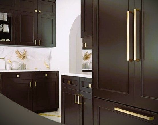 Dark brown kitchen cabinets with gold hardware. Marble backsplash, arched doorway.