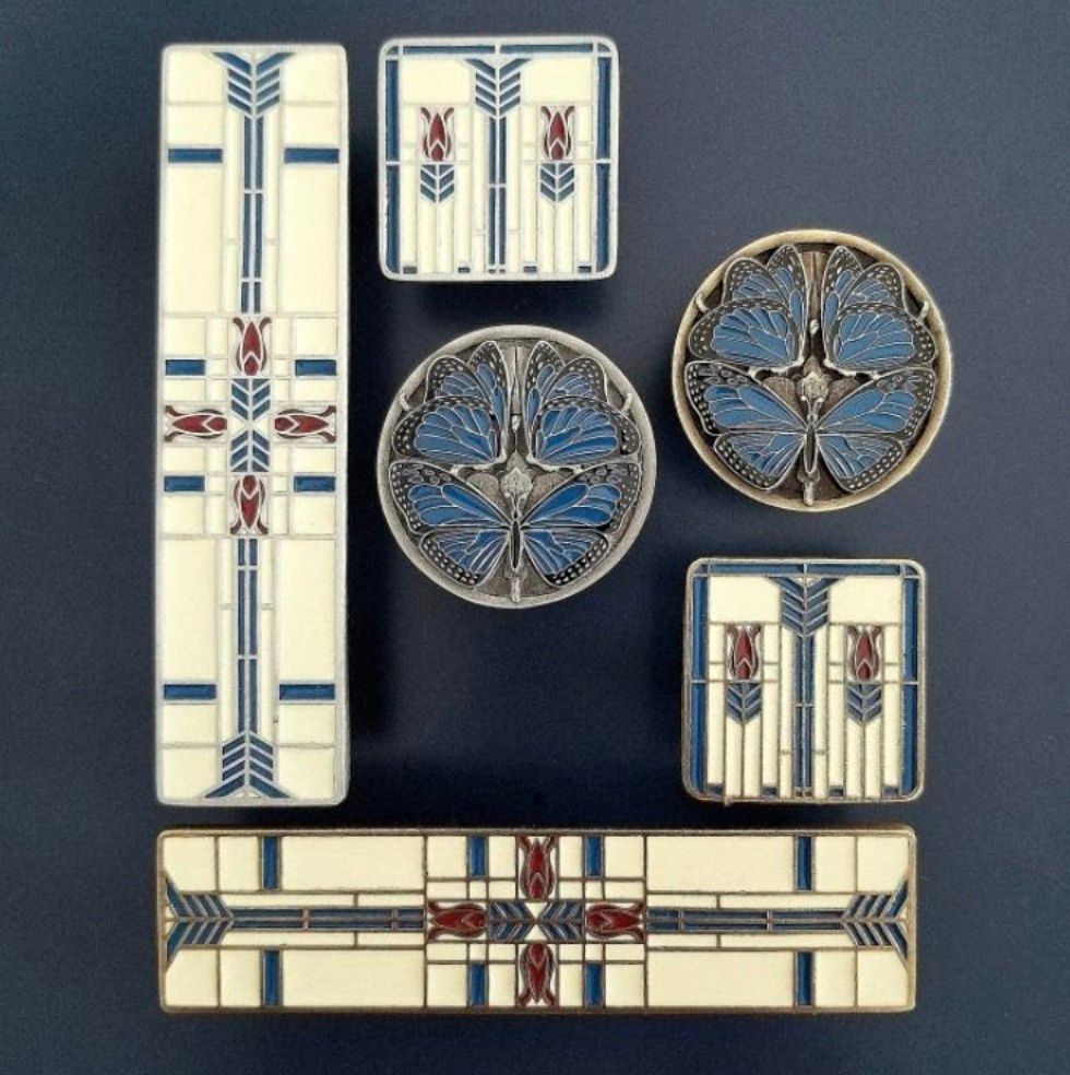 Seven decorative enamel pieces in white, blue, and red geometric designs on a dark background.
