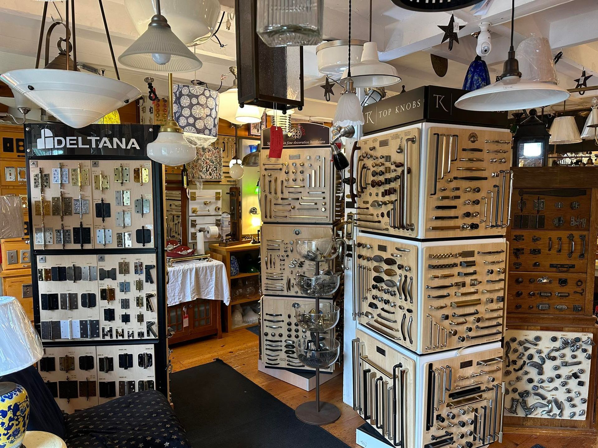 Interior shot of a lighting store. Display cases of light fixtures and hardware, with hanging lamps.