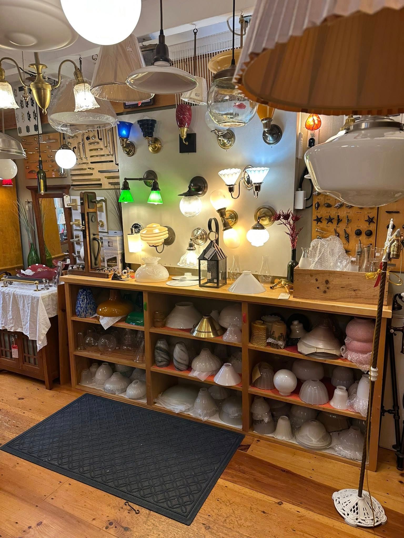 A shop displaying a variety of vintage lamps and light fixtures on shelves and walls.