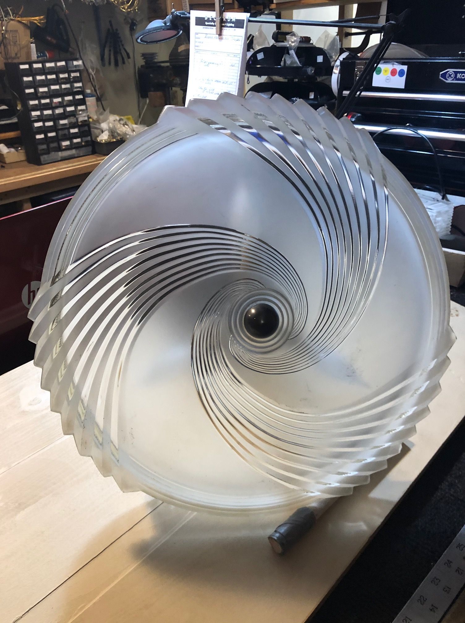 Frosted glass light fixture with spiraling etched design.
