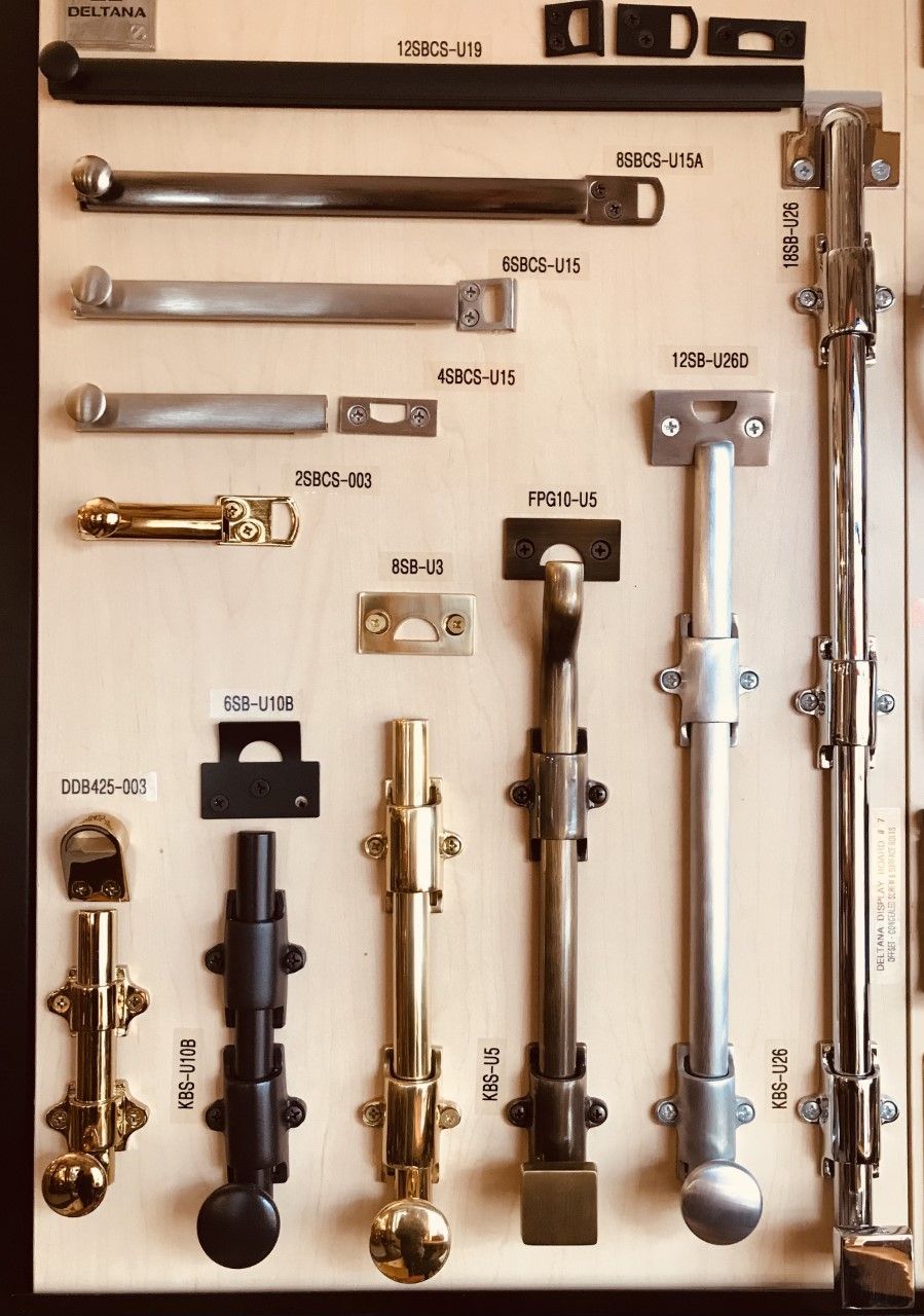 Display of various door bolts and latches in different finishes.