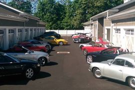 Outdoor view of our facility lined with luxury vehicles