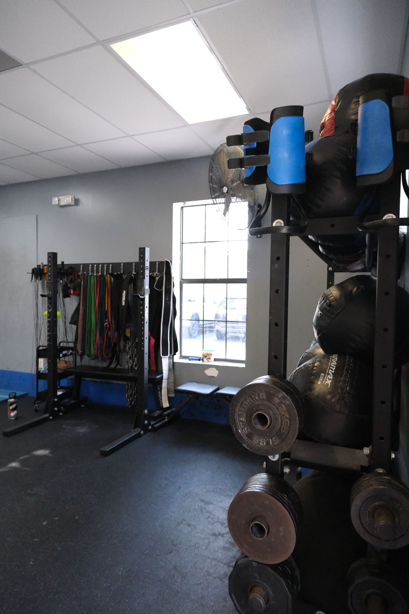 A gym with a lot of dumbbells and a window.