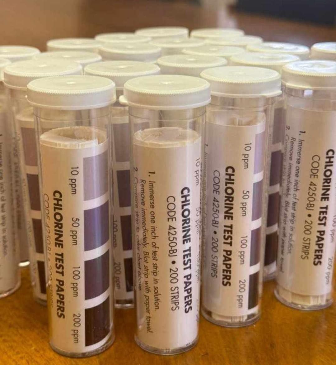 Varios tubos de plástico transparente que contienen tiras de prueba de cloro,
