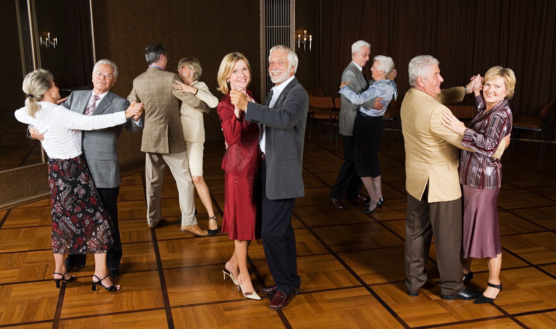Dance Holidays A group of older people are dancing on a wooden floor.