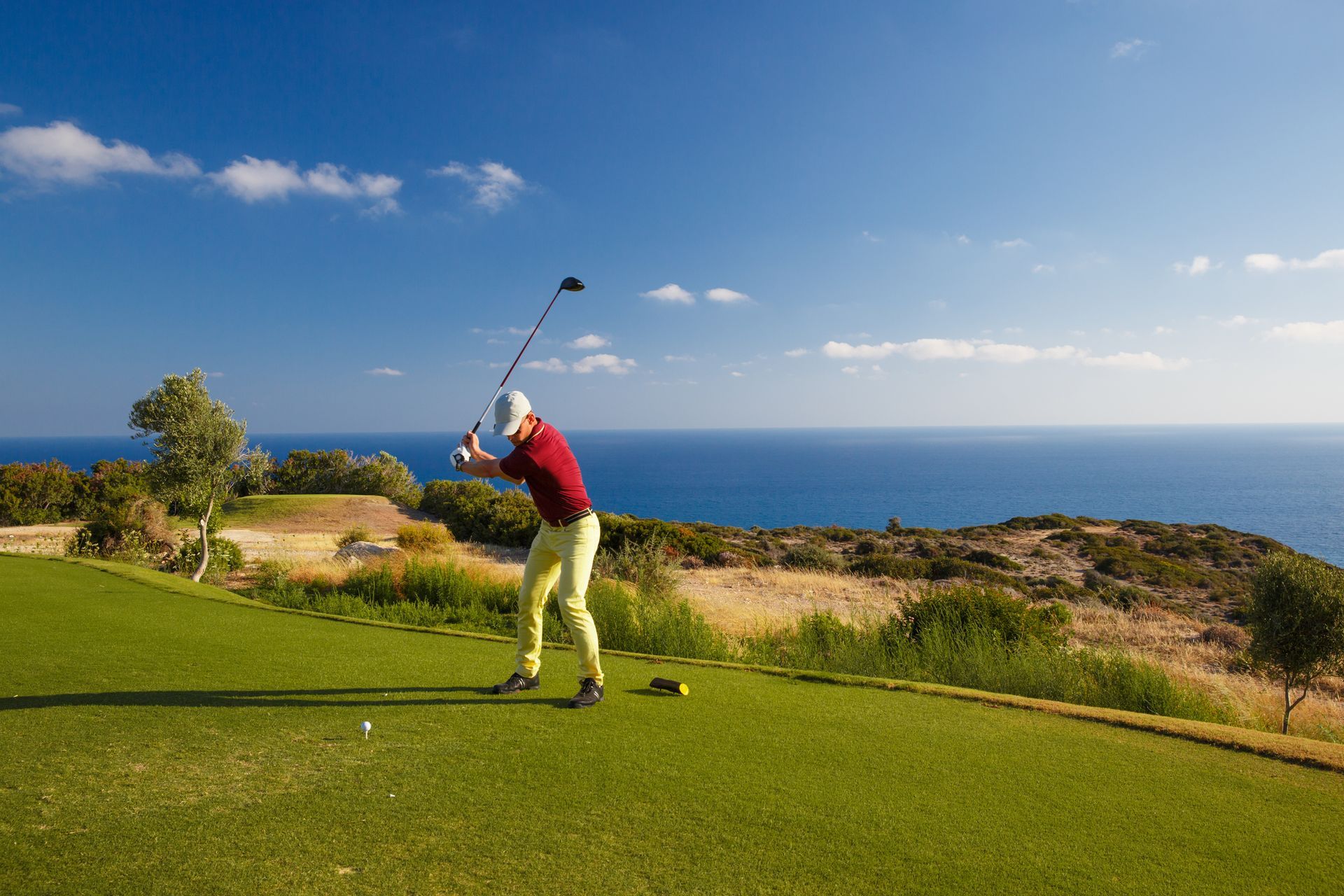 Golf Holidays. An aerial view of a golf course with mountains in the background.