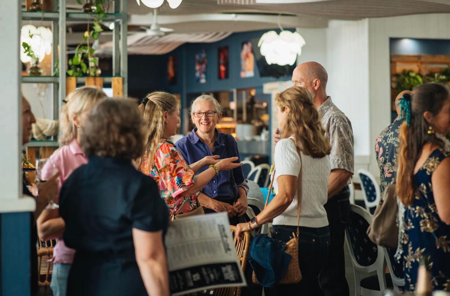 A Group of People Are Standing in a Room Talking to Each Other — Chop 'n Chill South West Rocks in South West Rocks, NSW