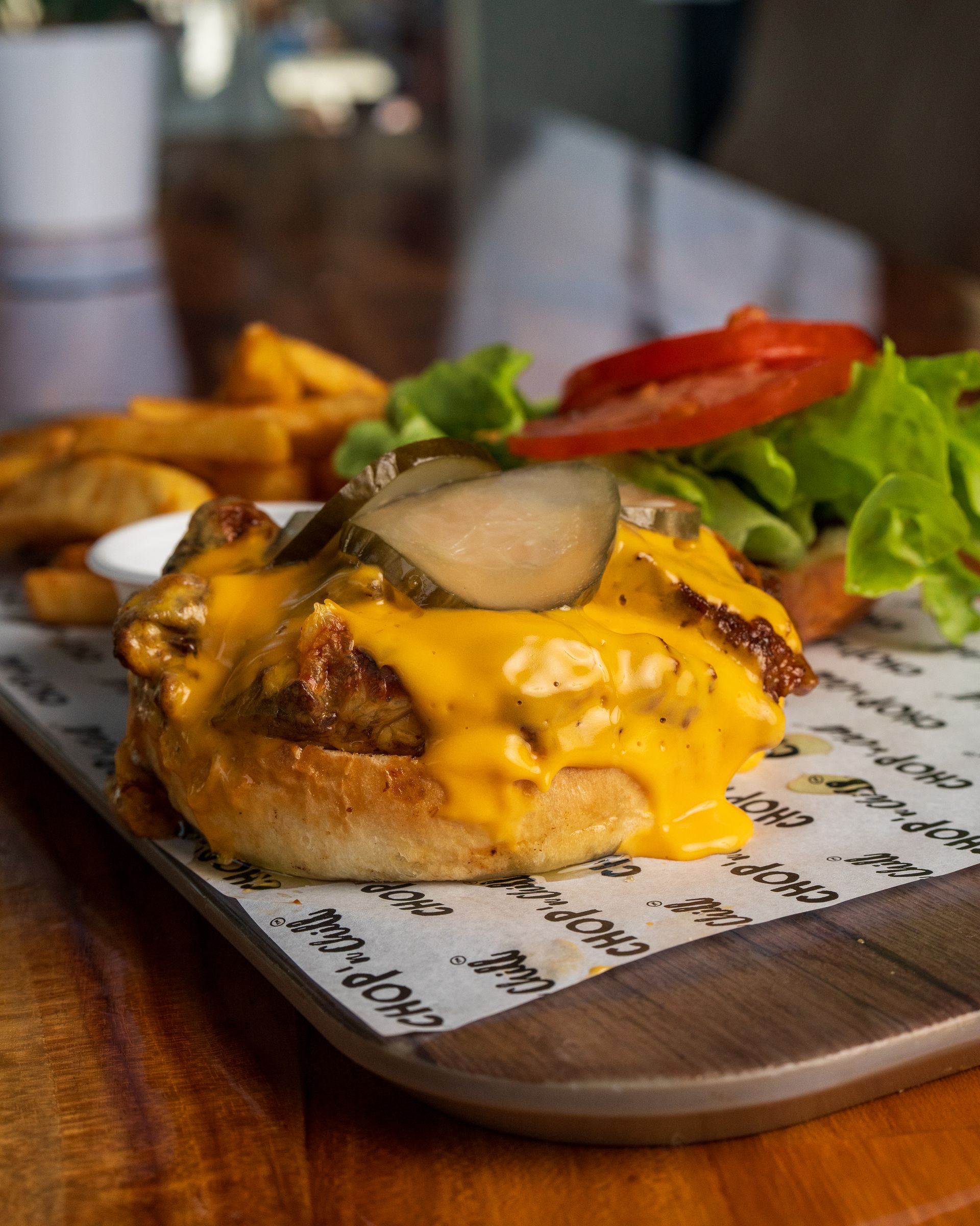 A Cheeseburger and French Fries on a Wooden Tray on a Table — Chop 'n Chill South West Rocks in South West Rocks, NSW