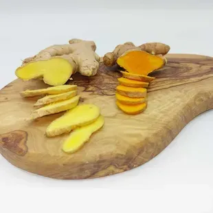 Le gingembre pousse dans un jardin entouré de fleurs et de feuilles.