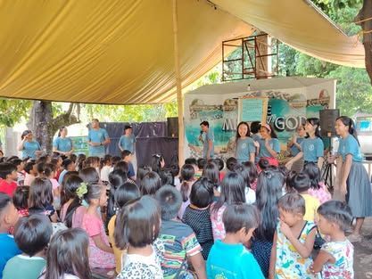 A large group of people are standing under a tent.