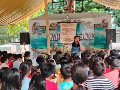 A woman is giving a speech to a large group of people.