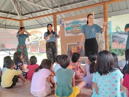 A group of children are sitting on the floor watching a presentation.
