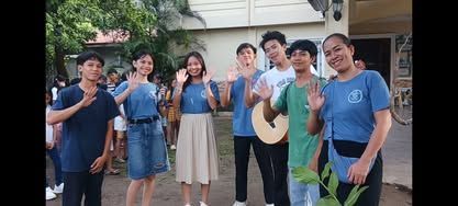 A group of people are standing next to each other in front of a house.