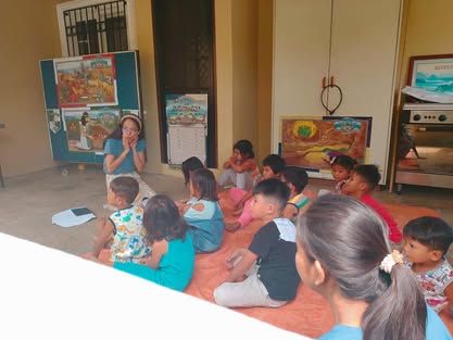 A group of children are sitting on the floor in a room.