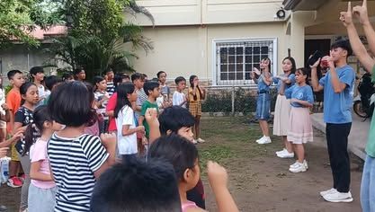 A group of children are standing in front of a house.