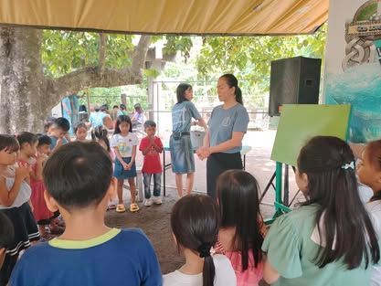 A group of children are standing in a circle under a canopy.