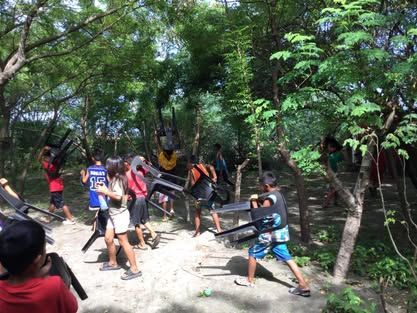 A group of people are standing in a forest holding swords.