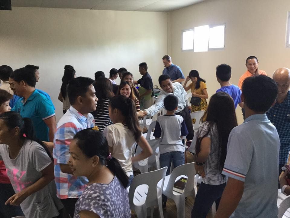 A large group of people are standing in a room.