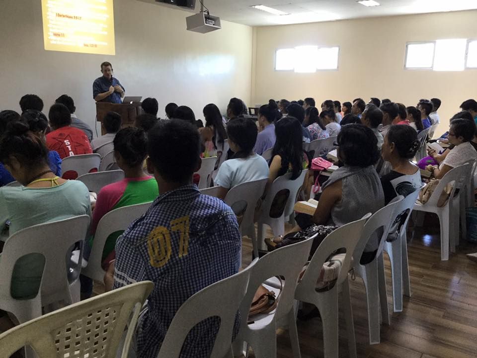 A man is giving a presentation to a large group of people
