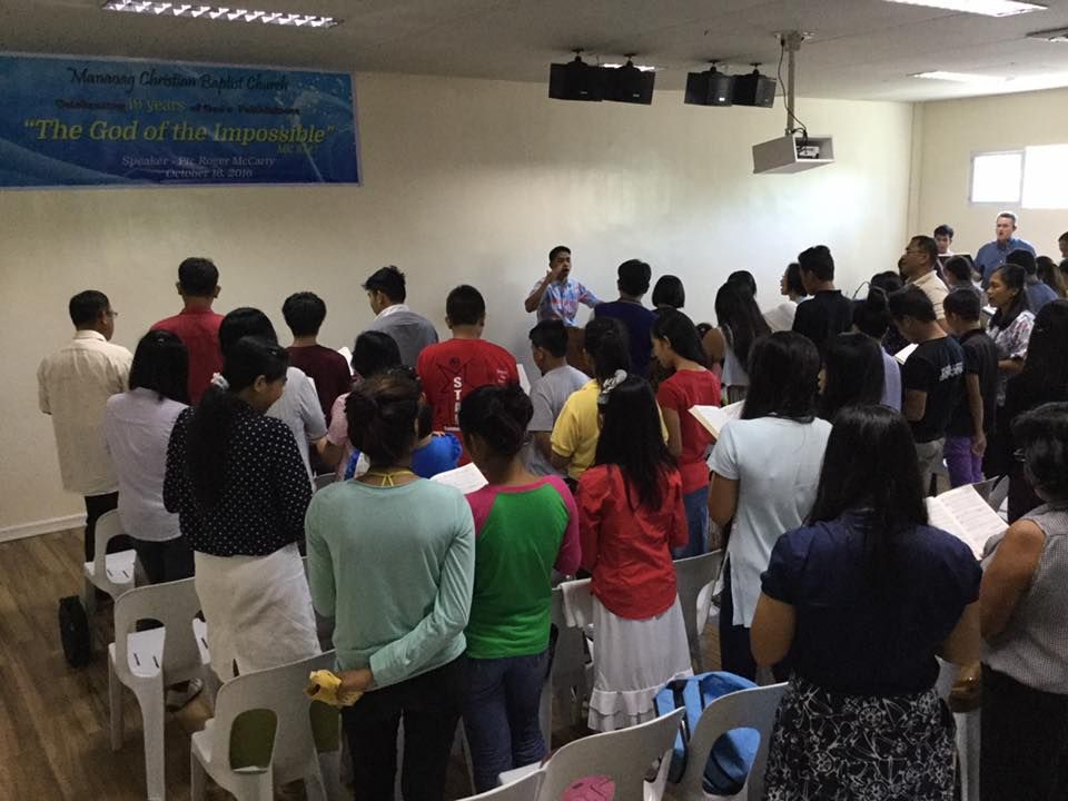 A large group of people are standing in a room.